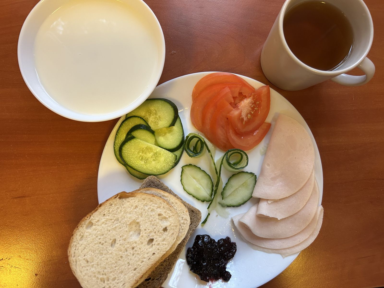 Płatki owsiane na mleku, chleb pszenny i żytni, pomidor, ogórek, wędlina, dżem